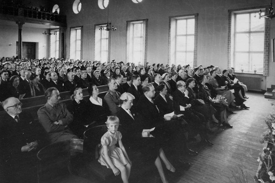 Invigning av Husliga seminariet i maj 1955. Bland gästerna fanns statsminister Tage Erlander och hertiginnan av Västerbotten, prinsessan Sibylla. Högtidstalen hölls hos grannen Folkskoleseminariet, med stor aula.  Trots olika stilar, storlek och tillkomsttider (Folkskoleseminariet byggdes 1923–1924) finns viss samhörighet mellan de två skolkomplexen – något som arkitekten Nils Tesch verkar ha strävat efter. Gösta Skoglunds arkiv, Folkrörelsearkivet i Västerbotten.