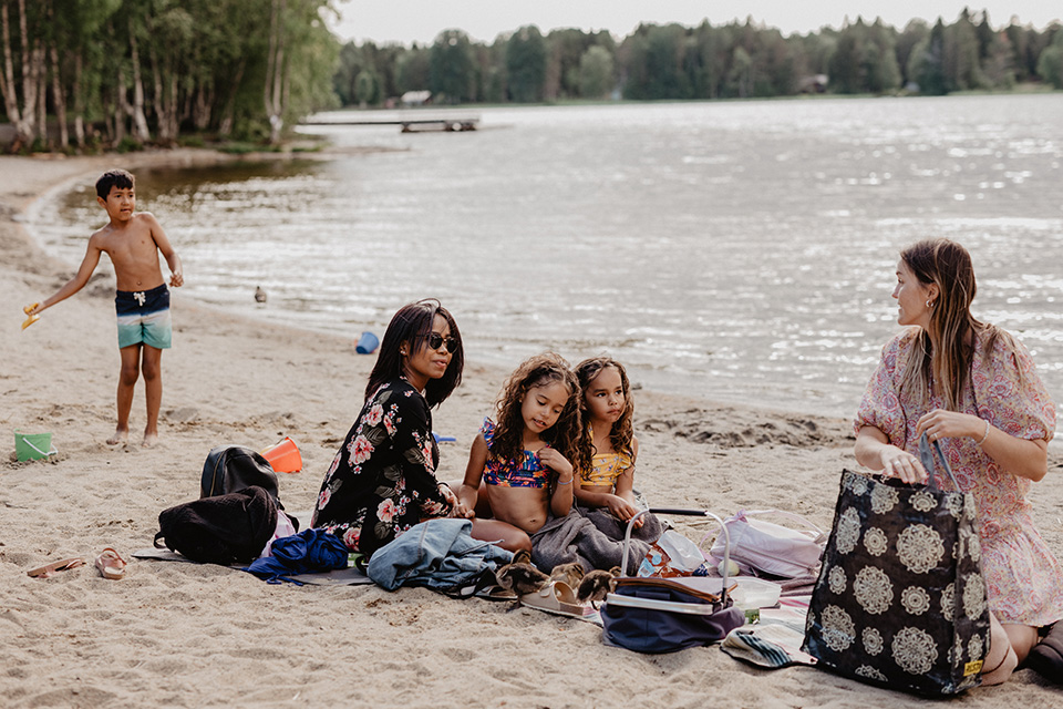 Familjer som umgås på en sandstrand vid Nydalajön