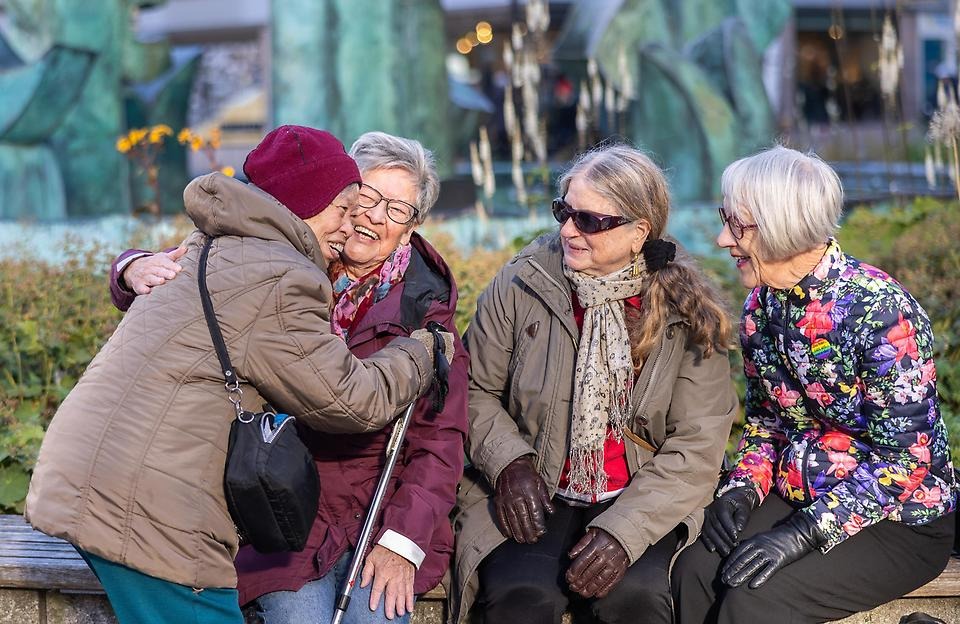 Glada vänner på en parkbänk